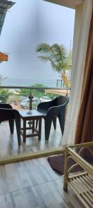 a balcony with chairs and a table and a view of the ocean at Casa de joana deluxe in Calangute