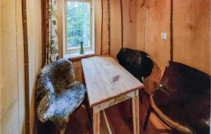 Habitación pequeña con mesa de madera y ventana. en Jakthuset en Vinslöv