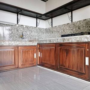 a kitchen with wooden cabinets in a room at Villa Arum Dalu in Semplak