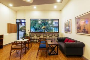 a living room with a couch and a table and chairs at Suite Home Boutique Hotel in Phnom Penh