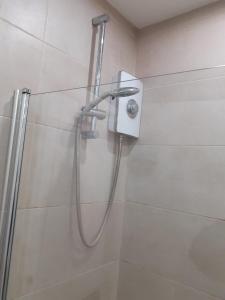 a shower with a hose in a bathroom at Celebrity Home in Woolwich