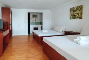 a hotel room with two beds and a television at RedDoorz @ The Central Inn Boracay Island in Boracay