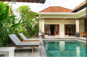 uma casa com piscina em frente a uma casa em Rendira villa 2 em Ubud
