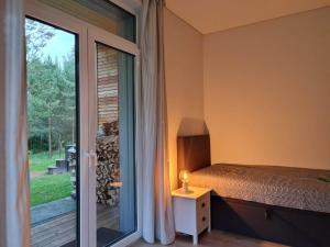 een slaapkamer met een bed naast een raam bij Miško Santorija in Ažuluokesa