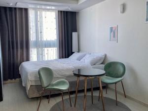 a bedroom with a bed and two chairs and a table at Moon Stay Star BnB in Daegu