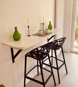 a table and a chair with vases and candles on it at B71 - Appartement im Herzen des Schwarzwalds in Schramberg