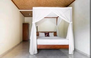 uma cama de dossel num quarto em Rendira villa 2 em Ubud