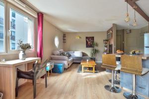 a living room with a couch and a table at T3 with balcony near the Stade de France - Welkeys in Saint-Denis