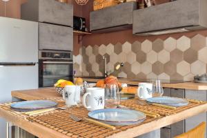 a kitchen with a table with plates on it at T3 with balcony near the Stade de France - Welkeys in Saint-Denis