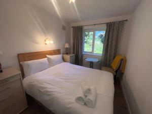 Un dormitorio con una cama blanca con dos pares de zapatos. en Wild Atlantic Way Cottage Galway en Galway