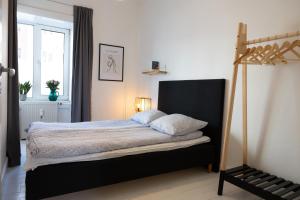 - une chambre dotée d'un lit avec un cadre noir dans l'établissement Stefania, à Aalborg