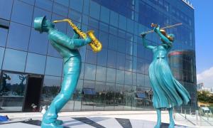 a statue of two women playing instruments in front of a building at Ulsan Tanibay Hotel & Wedding in Ulsan