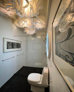 bagno con servizi igienici e soffitto decorato con un dipinto. di JARITT NyMMANH a Chiang Mai