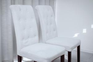 duas cadeiras brancas sentadas ao lado uma da outra em City Apartments at Freedom Plaza em Windhoek