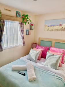een slaapkamer met 2 bedden en een afstandsbediening bij The Wardens Escape - Tattershall Lakes Country Park in Tattershall