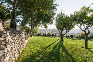 a garden with trees and a stone wall at Giardino Sul Duomo in Ragusa