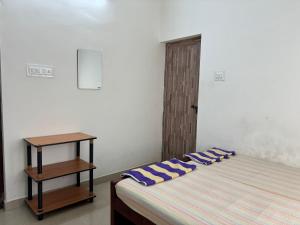 ein Schlafzimmer mit einem Bett mit blauen Kissen darauf in der Unterkunft Rajas Basera Homestay in Alappuzha