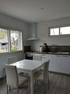 uma cozinha com uma mesa e cadeiras numa cozinha em Logement-Barry entre Tarbes et Lourdes 