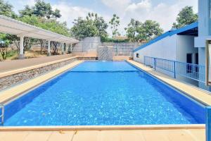 uma grande piscina com água azul em Papa Kana Farm Mitra RedDoorz At Pacet Mojokerto em Mojokerto