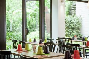 a dining room with tables and chairs and a window at ibis Styles Paris Mairie de Montreuil in Montreuil