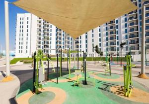 einen Spielplatz mit grüner Ausstattung vor einem Gebäude in der Unterkunft Jewel of the Canal 809WB3 in Abu Dhabi
