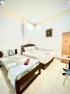 1 dormitorio con 2 camas en una habitación en Wisma Mutiara, en Padang