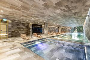 una piscina en un edificio con sillas y una piscina en St Kilda Road 2 Bedrooms Apartment * swimming Pool, en Melbourne