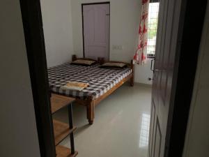 ein kleines Schlafzimmer mit einem Bett und einer Leiter in der Unterkunft Rajas Basera Homestay in Alappuzha