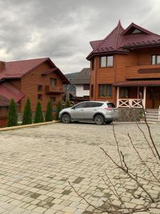 um carro prateado estacionado em frente a uma casa em Aura Karpat em Bukovel