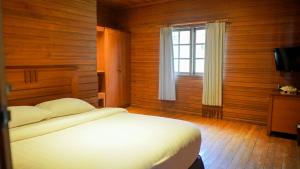 een slaapkamer met een wit bed en een raam bij KTM Resort Batam in Sekupang