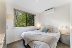 Schlafzimmer mit einem Bett und einem Fenster in der Unterkunft BIG4 Tasman Holiday Parks - Bright in Bright