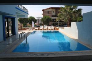 a large swimming pool with chairs and a building at Sun Hotel in Çeşme