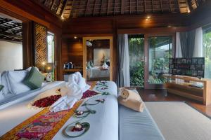 een slaapkamer met een bed met een handdoek erop bij Black Penny Villas Ubud in Ubud