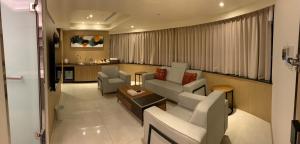 a living room with a couch and chairs and a table at Michi Hotel - Luodong in Luodong
