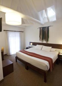 ein Schlafzimmer mit einem großen Bett in einem Zimmer in der Unterkunft Tierra Viva Cusco Saphi Hotel in Cusco