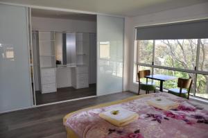 a bedroom with a bed and a table and a window at Modern 3-bedroom Katoomba townhouse (nature view) in Katoomba