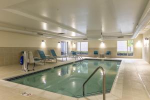 a pool in a hotel with chairs and tables at TownePlace Suites by Marriott Nashville Goodlettsville in Goodlettsville