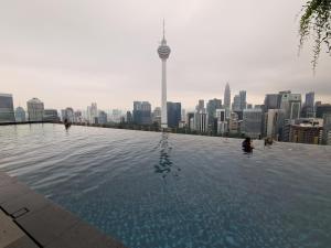 uma piscina de beiral infinito com vista para a cidade em Romantic Log Cabin 3 - in the Heart of KL city (walk to KL Tower/KLCC/Bukit Bintang) em Kuala Lumpur