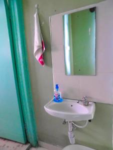 a bathroom with a sink and a mirror and a toilet at Shamza Airbnb in Nakuru