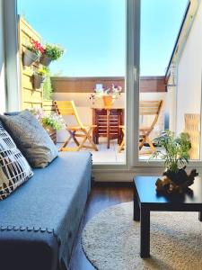 a living room with a couch and a patio with a table at Beautiful Studio at Geneva airport Ferney Voltaire in Ferney-Voltaire