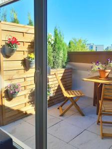 a patio with a wooden fence and a table and a chair at Beautiful Studio at Geneva airport Ferney Voltaire in Ferney-Voltaire