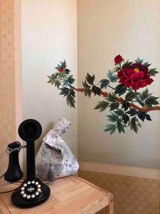 a painting of flowers on a wall next to a table at Timeless Hanok In Jamsil Serenity in Seoul