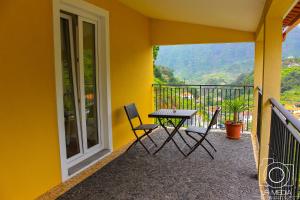 eine Terrasse mit einem Tisch und Stühlen auf dem Balkon in der Unterkunft Solar do Carvalho in São Vicente