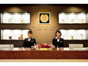Dos mujeres sentadas en un mostrador en un restaurante en Grand Park Hotel Panex Hachinohe / Vacation STAY 77784, en Hachinohe