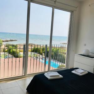 1 dormitorio con cama y vistas al océano en Gorgona Seafront Villas 3 Bedroom With Private Swimming Pool, en Ayia Napa