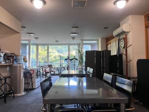 d'une salle à manger avec une table, des chaises et une fenêtre. dans l'établissement フューデイズコンドミニアム定山渓106号室, à Jozankei
