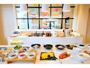stół z wieloma miskami i talerzami jedzenia w obiekcie Grand Park Hotel Panex Hachinohe / Vacation STAY 77754 w mieście Hachinohe