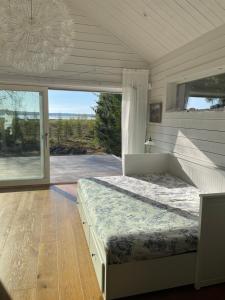 a bedroom with a bed and a large window at Beautiful house in the nature with private river access in Luleå