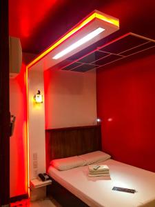a room with a bed with a red wall at Harimariz Dormitory Official in Dumaguete