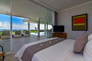1 dormitorio con 1 cama grande y vistas al océano en Deep Blue Villa Managed By LBV, en Buleleng